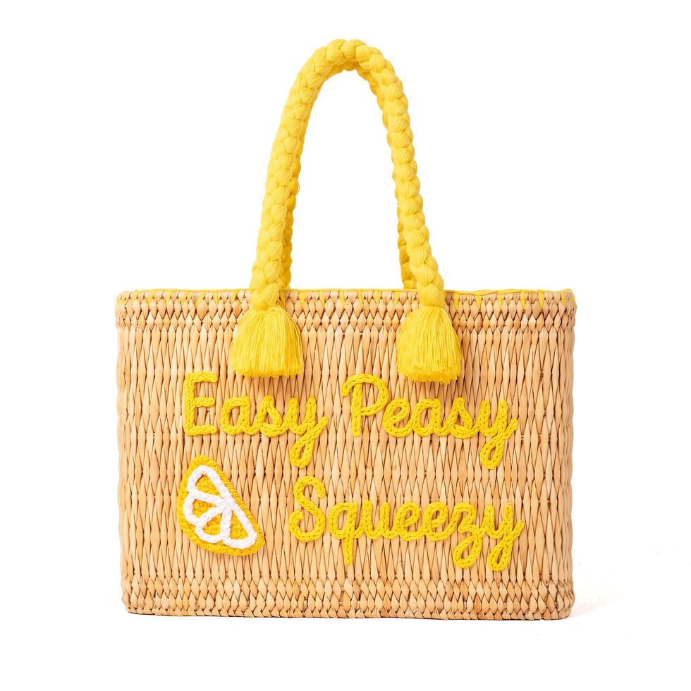 Handwoven Moroccan wicker beach tote with yellow braided handles and Easy Peasy Lemon Squeezy embroidered lemon design summer bag