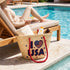 Handwoven straw beach tote with “I Love USA” embroidery and American flag heart, natural palm leaf basket with red rope handles, stylish patriotic travel and summer bag for women