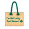 Handwoven Moroccan wicker beach bag with green braided handles embroidered with I’m Not Lucky Just Blessed and shamrock design