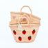Hand-embroidered straw basket with multiple red strawberries, green leaves, and natural palm leaf texture