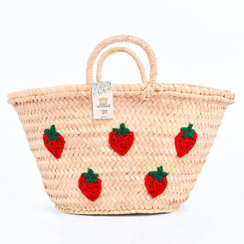 Hand-embroidered straw basket with multiple red strawberries, green leaves, and natural palm leaf texture