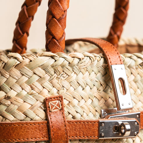 Small luxury Hermès-inspired straw handbag with braided leather handles and secure closure 2
