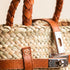 Small luxury Hermès-inspired straw handbag with braided leather handles and secure closure 2