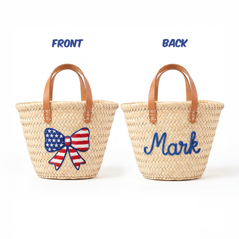 Personalized USA kids straw basket with embroidered American flag bow, small handwoven palm leaf tote with leather handles, custom name on back, patriotic children’s beach and birthday gift bag