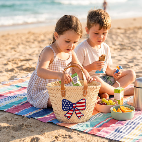 Personalized USA kids straw basket with embroidered American flag bow, small handwoven palm leaf tote with leather handles, custom name on back, patriotic children’s beach and birthday gift bag