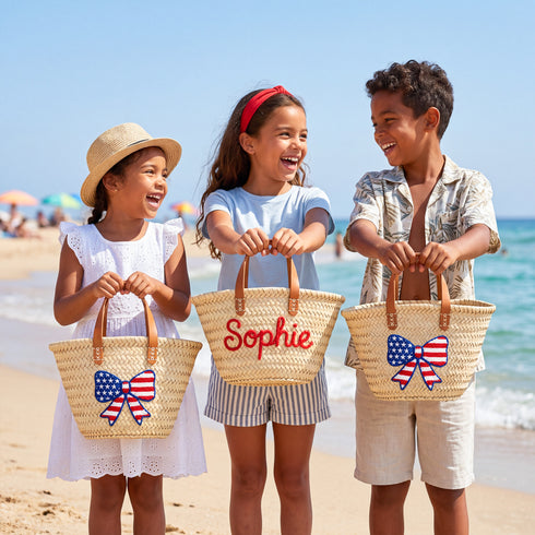 Personalized USA kids straw basket with embroidered American flag bow, small handwoven palm leaf tote with leather handles, custom name on back, patriotic children’s beach and birthday gift bag