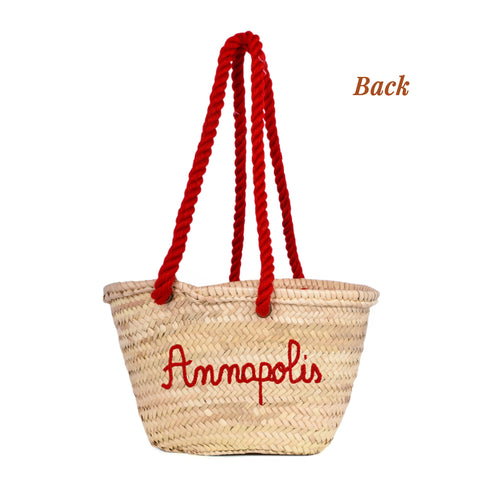 Handwoven straw basket with embroidered USA flag and red braided thread handles