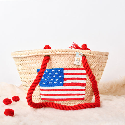 Handwoven straw basket with embroidered USA flag and red braided thread handles