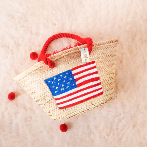 Handwoven straw basket with embroidered USA flag and red braided thread handles