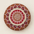 Top view of a stuffed dark tan round fusion pouf with intricate red, cream and white Amazigh Berber embroidered motif fabric