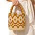 Close-up of handmade Moroccan raffia bucket bag with goldenrod and beige scalloped cotton embroidery and beaded top handle