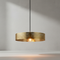 Gold pendant light hanging against a neutral background