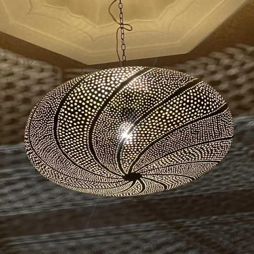 Close-up of a glossy Moroccan brass pendant lamp with intricate craftsmanship