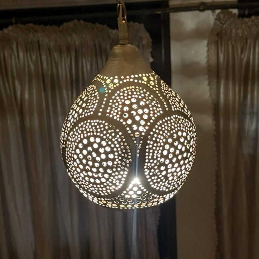 Handmade Moroccan brass pendant lamp installed in a dining area