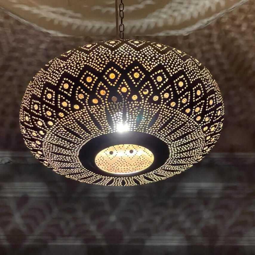 Moroccan brass pendant light casting intricate patterns in a modern living room