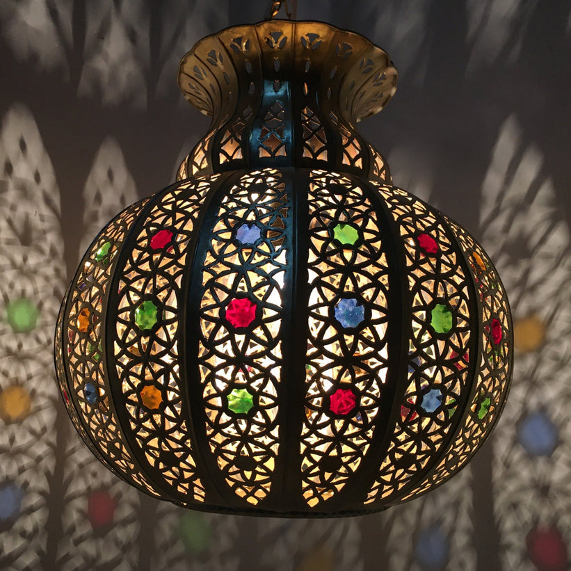 Moroccan pendant light with intricate metalwork detail hanging from a chain