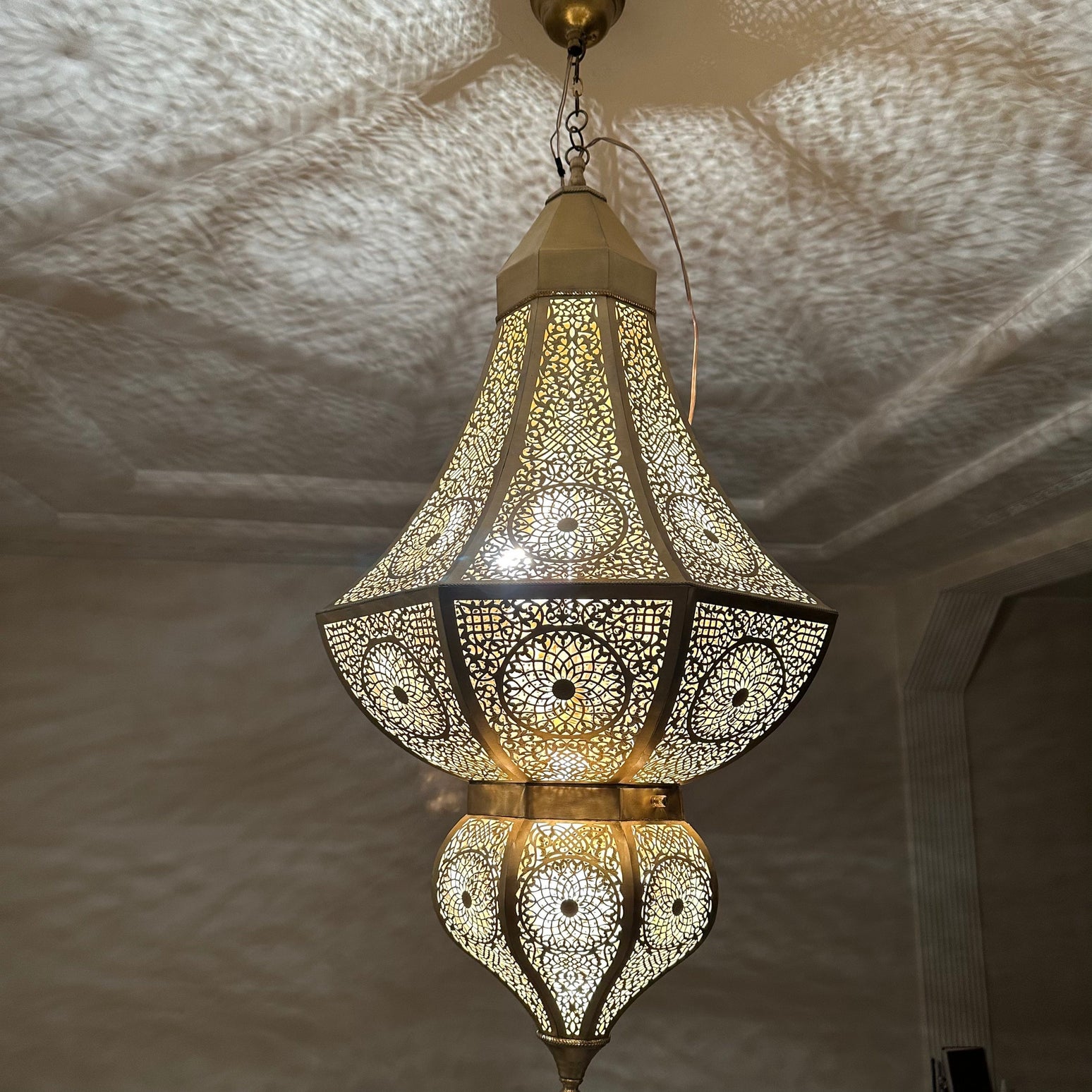 Intricate Moroccan brass chandelier casting beautiful shadow patterns