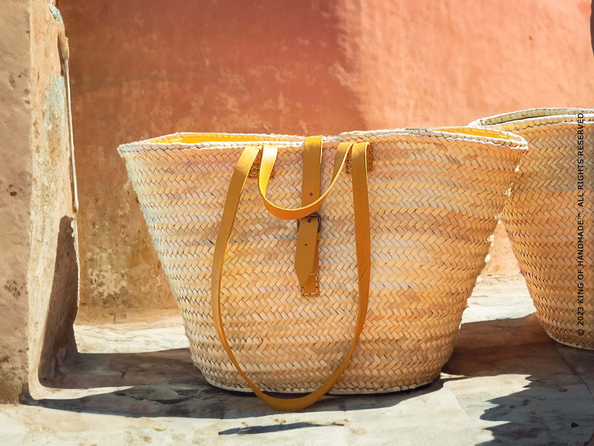 Close-up of a handmade large straw beach bag with leather handles