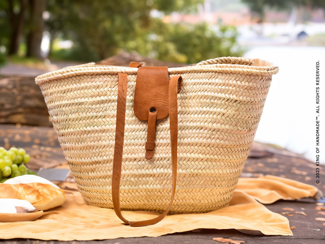 A large woven straw beach bag with leather handles