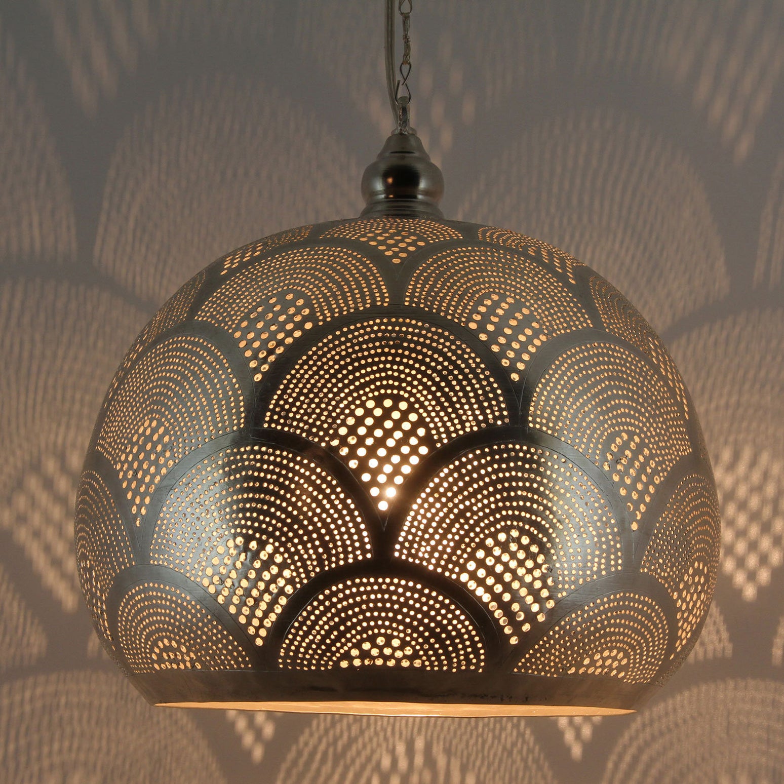 Ornate Moroccan pendant light casting intricate shadows