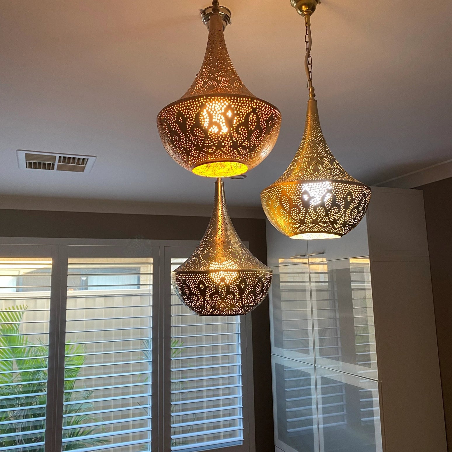 Moroccan lamp casting intricate light patterns in a modern living room