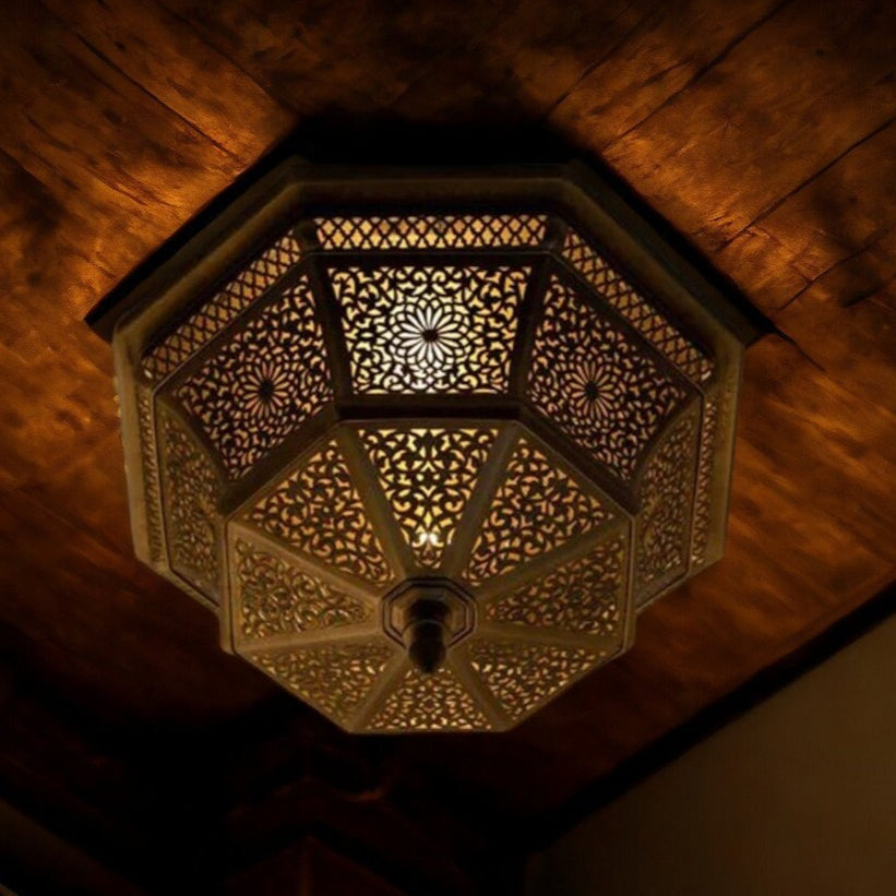 An ornate black Moroccan-style hanging pendant light with intricate metalwork and glass panels, perfect for adding a touch of exotic elegance to a dining room or living space.