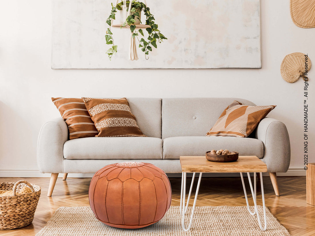 Tan leather ottoman pouf in a living room setting