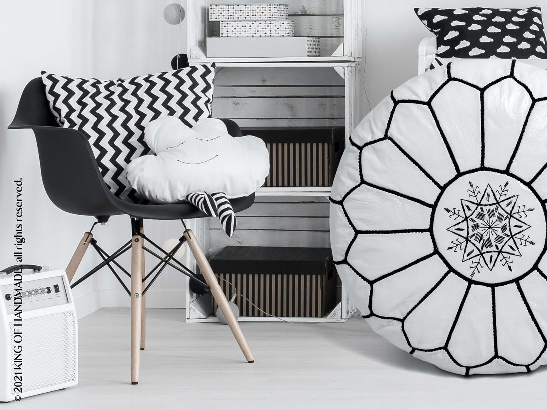 Black and white patterned ottoman pouf in a bedroom setting