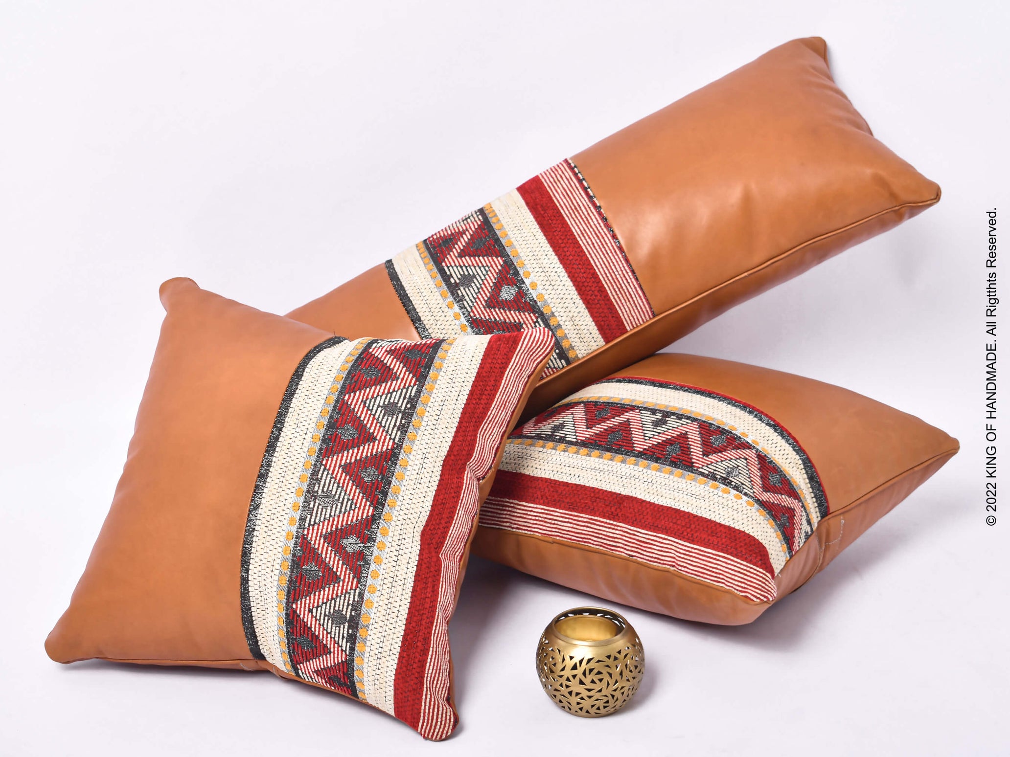 Set of three boho-style pillow covers in tan leather with intricate stitching